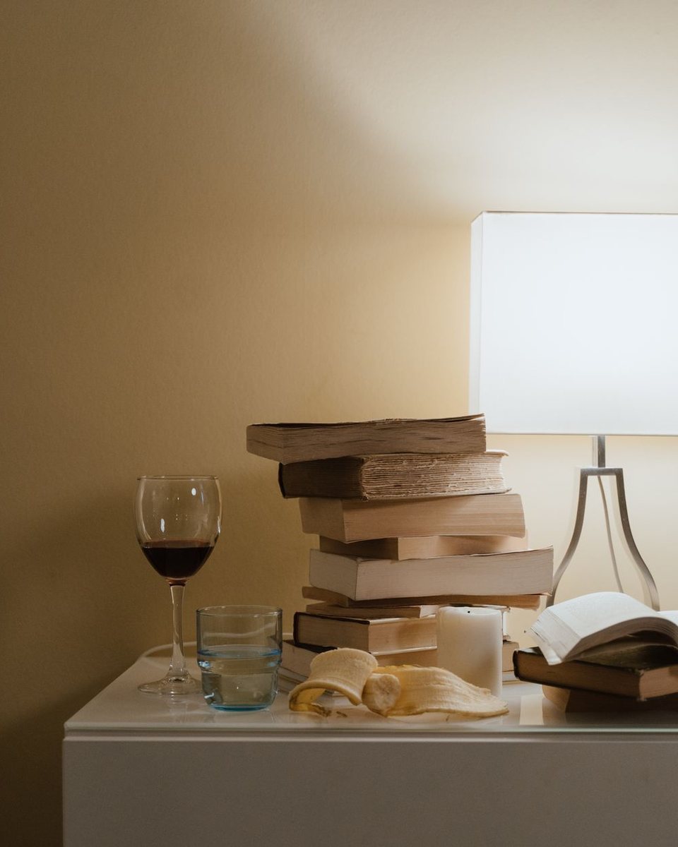 A bedside table with a carafe and a reading lamp